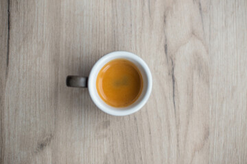Cup with espresso on a white wood top view. Espresso. Coffee creams.