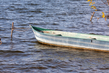 Naklejka premium Small wooden boat in the water at the pier
