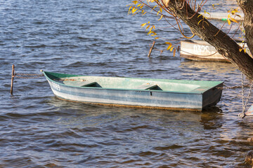 Fototapeta premium Small wooden boat in the water at the pier