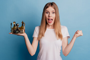 Photo of excited winner cute princess lady celebrate victory wear golden crown open mouth on blue...
