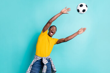 Photo of impressed brunette hairdo millennial man catch ball wear yellow t-shirt isolated on cyan...