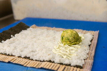 Manos preparando un rollo de Uramaki 
