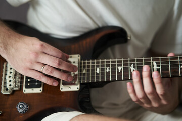 Fototapeta na wymiar Hands of a musician playing electric guitar close-up. High quality photo