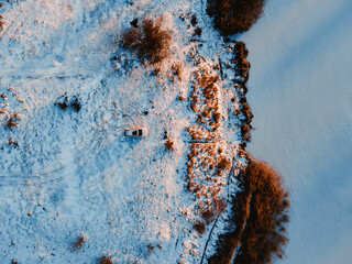 aerial view of the suv car at the beach of frozen lake on sunset