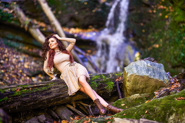 a beautiful woman sitting by a waterfall in different positions.