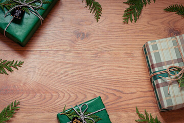 Christmas concept frame with gift boxes on the wooden background. Winter holiday greeting card. Copy space