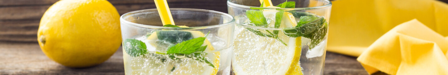 banner of Lemonade or mojito cocktail with lemon and mint with ice. Cold summer refreshing drink decorated with yellow napkin