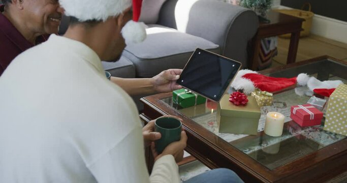 Smiling father and son making christmas video call on digital tablet with copy space at home