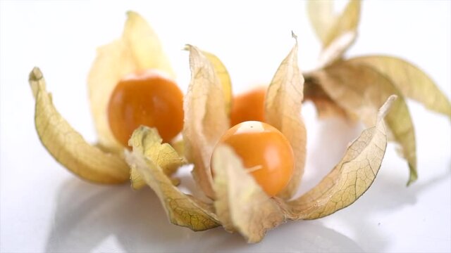 Physalis fruit closeup. Groundcherry fruits rotated over white background. Ripe fresh Physalis plant, yellow berry. Cape gooseberry. Goldenberry. Slow motion 4K UHD video. 