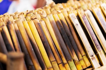 Closeup of Khao Lam, glutinous rice baked in a bamboo cylinder, thai street food market