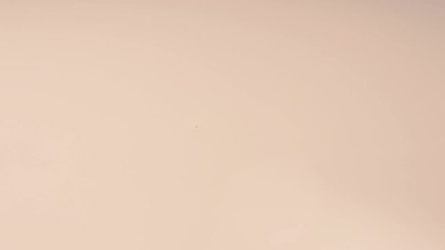 A drop falls on a beige background, foundation. cream, beige. Foundation template.