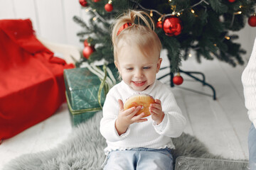 Little girl eating donuts in a festive room.
