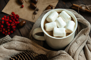Festive background for recording, top view.An envelope made of craft paper for writing on a wooden table. Autumn-winter. Festive mood. A mug of coffee.