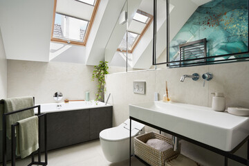 Stylish bathroom design with panels painted in green on the wall. Bathtub, towels, rattan baskets...