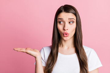 Portrait of attractive amazed funky girl holding on palm copy empty blank space ad isolated over pink pastel color background