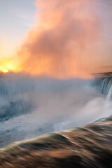 Vibrant sunrise illuminating the mist over Niagara Falls, Ontario Canada. 