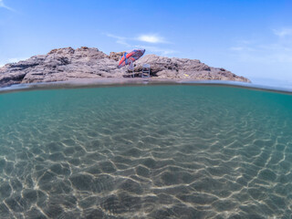 Island and half underwater mediterranean sea, sandy underwater in the Mediterranean Sea, The nature of marine life and umbrella of the Mediterranean, undersea and beach sand.