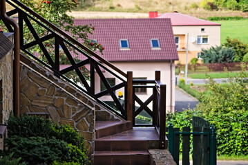 Kamienne schody z drewnianą poręczą . Dom na wzgórzu . Stone stairs with a wooden rail. House on the hill. - obrazy, fototapety, plakaty