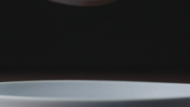 Slow motion cooked pesto fusilli fall in blue plate closeup
