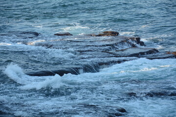 Obraz premium Sea Waves Crashing on the Rocks with White Foam. Swirling frothy foamy sea water over the rock near Akko(Acre) Israel