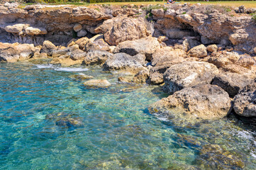 The charm of the spring coast of Paphos consists of the bright color of the sea, bizarre coastal rocks and a scattering of large and small blooming plants    