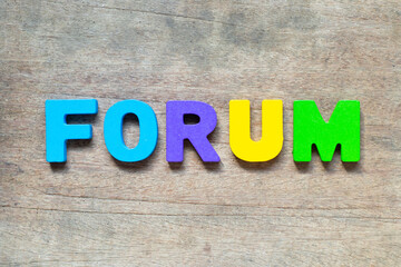 Color alphabet letter with word forum on wood background