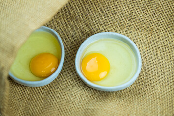 Two raw egg in bowl on sack