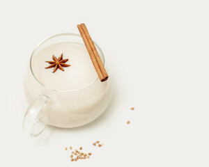 Natural non lactose buckwheat milk. Vegan food composition with glass cup of plant milk with a cinnamon stick and anise on a white table. Vegan healthy milk products. eco friendly food banner