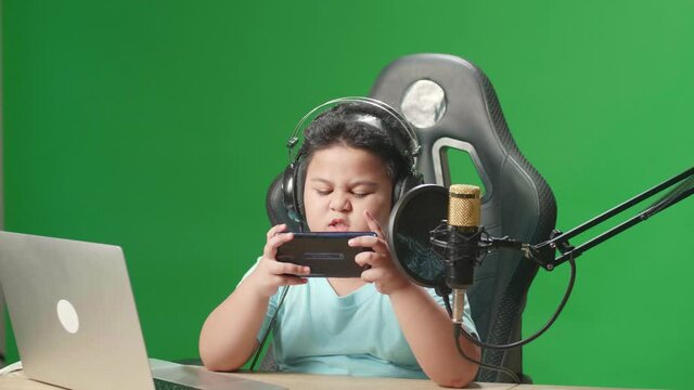 Camera And Asian Little Boy Playing Video Game With Mobile Phone Then Lose The Game While Live Stream On Green Screen 
