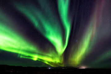 Northern lights, Aurora Borealis in the night sky, Iceland. These colourful curtains of dancing lights can illuminate the night sky