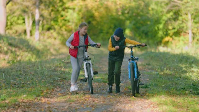 couple of children walking in nature with bicycles