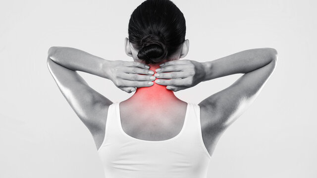 Back view of unrecognizable woman touching and massaging her neck