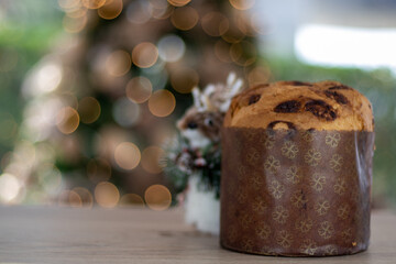 Christmas dinner, delicious Panettone in the background blurred Christmas tree