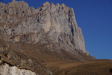 Mountain view on a clear autumn day. Mountains in Ingushetia. Landscape in the mountains in autumn. Rocks and trees in a mountainous area. Base jumping mountain.  