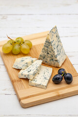 blue cheese on wooden board with grapes