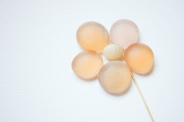 Orange flower made from glass stones on white paper. Copy space