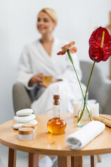 Obraz na płótnie Canvas massage tools near plants in vase near blurred client