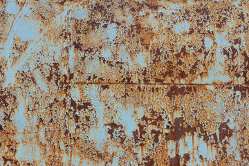 A rusty blue metal wall with fallen paint, a rusty background.