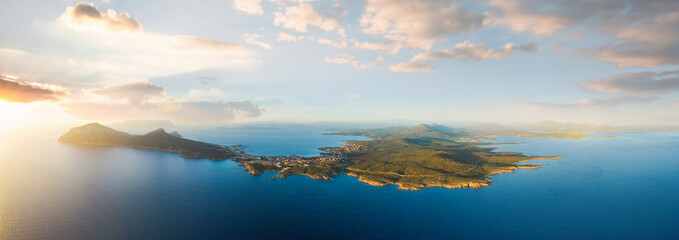 Fototapeta na wymiar View from above, aerial shot, stunning panoramic view of Golfo Aranci during a beautiful sunrise. Golfo Aranci is a village that extends along a strip of land into turquoise sea. Sardinia, Italy.
