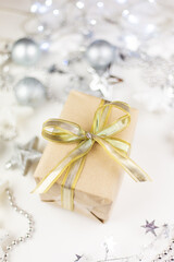 In the center of the assorted Christmas toys, there is a golden gift box created from kraft paper on a white background.