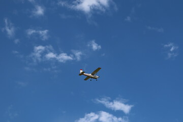 Little airplane in a blue sky. Transportation and aircraft. Flying  and transport. Vacation and travel.