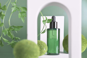 green bottle with dropper on modern stage with arch and grass balls. essential parsley oil for skin repair and whitening. anti age care for face and neck.