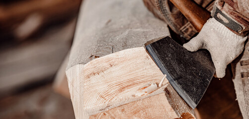 Banner closeup Carpenter with axe working with log wooden. Woodwork job, house frame building
