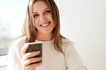 Content woman with cup of coffee in morning