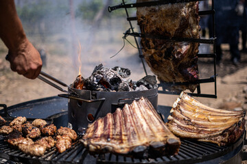 Traditional Argentine ribs grilled with charcoal and fire - obrazy, fototapety, plakaty