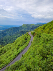 mountain curvy tarmac road with hill range background and dramatic sky at morning