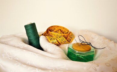 Ago, filo,  set per cucire posizionati su un tessuto di seta