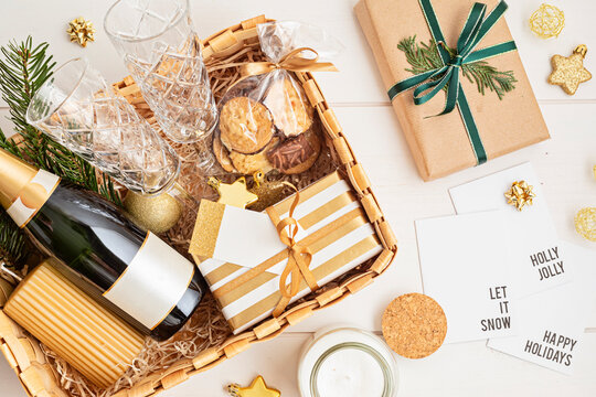 Refined Christmas gift basket for romantic holidays with bottle of champagne, wine glasses, cookies and candle. Corporate or personal present for family and friends.