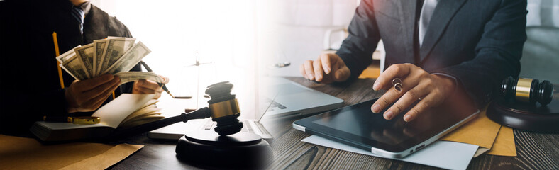 Justice and law concept.Male judge in a courtroom with the gavel, working with, computer and docking keyboard, eyeglasses, on table in morning light