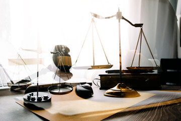 Justice and law concept.Male judge in a courtroom with the gavel, working with, computer and docking keyboard, eyeglasses, on table in morning light